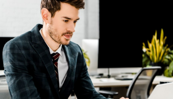 young man in suit working with his laptop