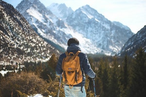 Backpacker infront of snowy mountains