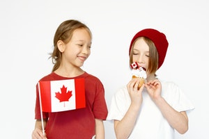 Two Canadian Kids Together holding a flag and cupcake
