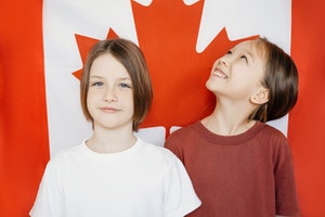 Kids smiling infront of Canada flag