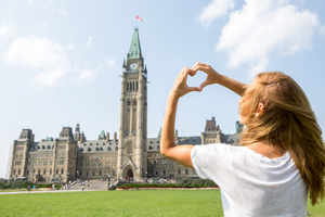 woman making a heart sign with hands in Canada